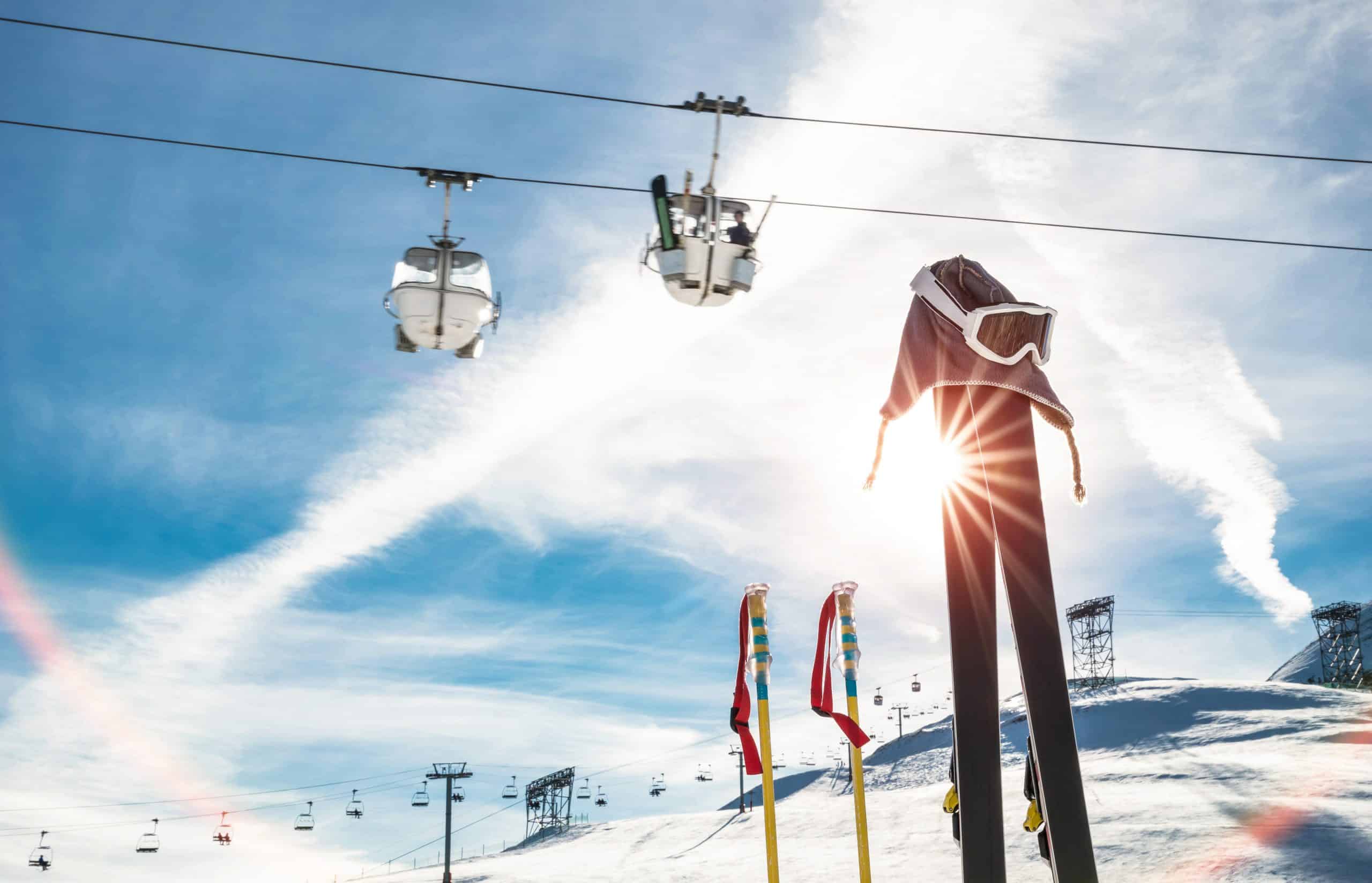 Skiing goggles and skis poles at resort glacier with chair lift