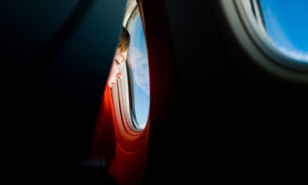 person looking at the window of an airplane