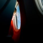 person looking at the window of an airplane
