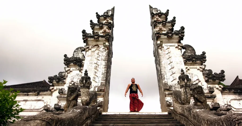Pura Kehen à Bali : visiter le temple du feu en couple, sans tomber dans le piège à touristes A man stands at the historic Pura Lempuyang Luhur Temple in Bali, showcasing traditional culture and architecture.