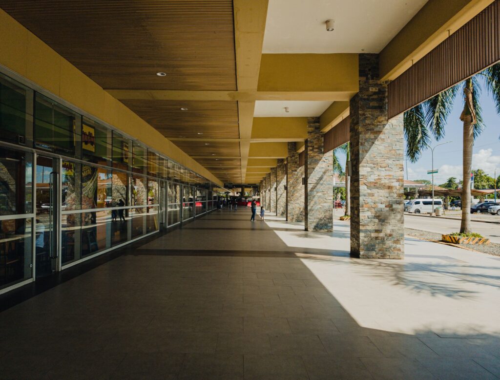 A sunlit shopping arcade in Puerto Princesa, Philippines, showcasing modern architecture.