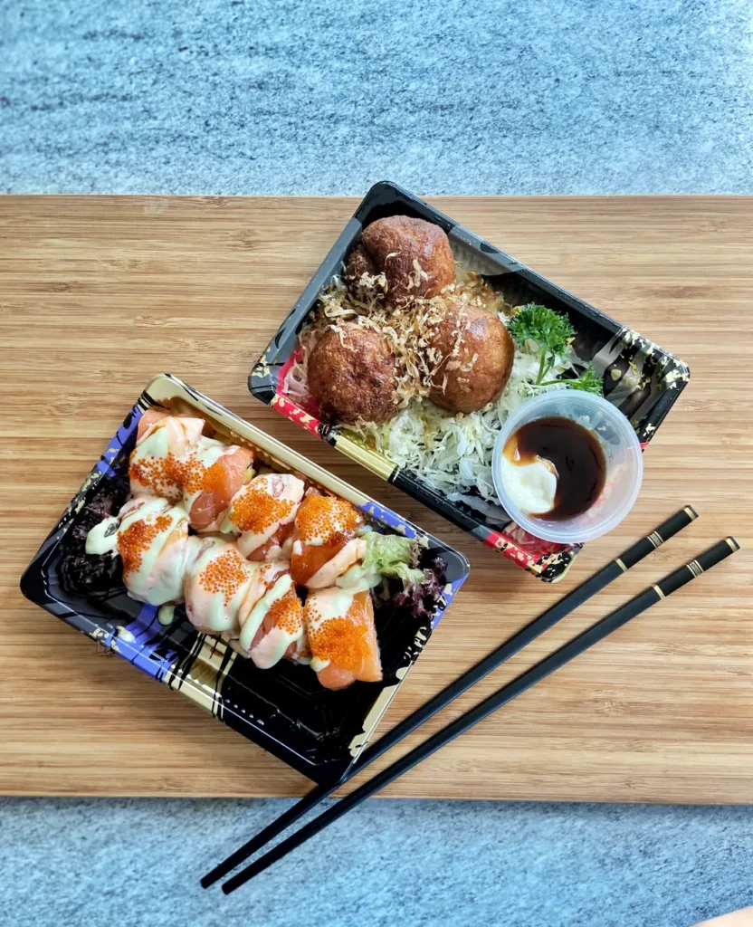 A vibrant Japanese bento box with sushi rolls and takoyaki, perfect for a light lunch.