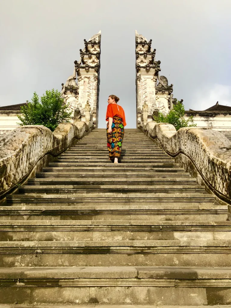 A woman walks up the stairs of the iconic Pura Lempuyang Hindu temple in Bali, Indonesia.