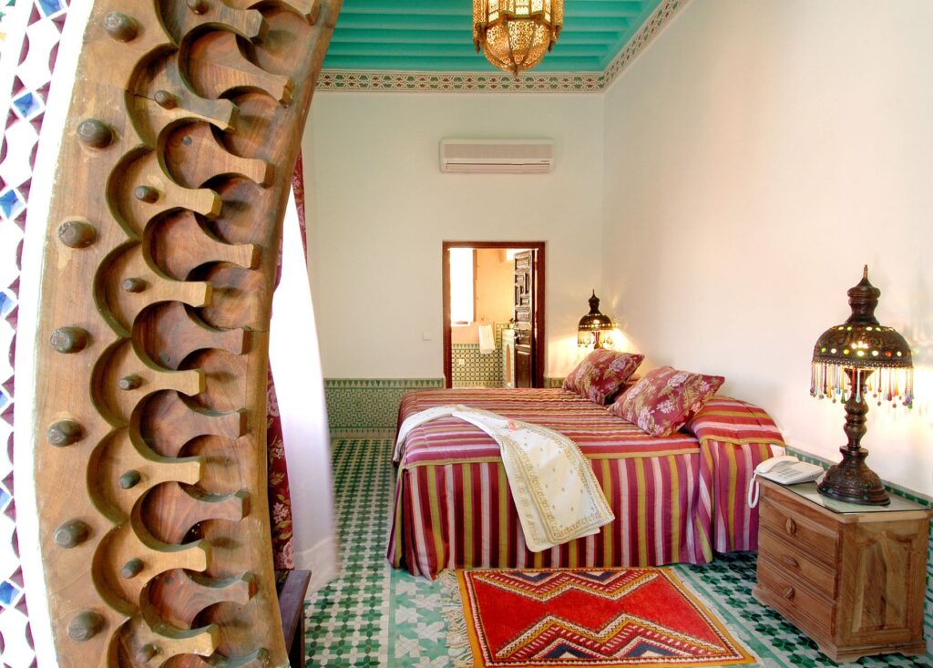 Beautiful Moroccan bedroom interior in Marrakech with traditional decor and colorful textiles.