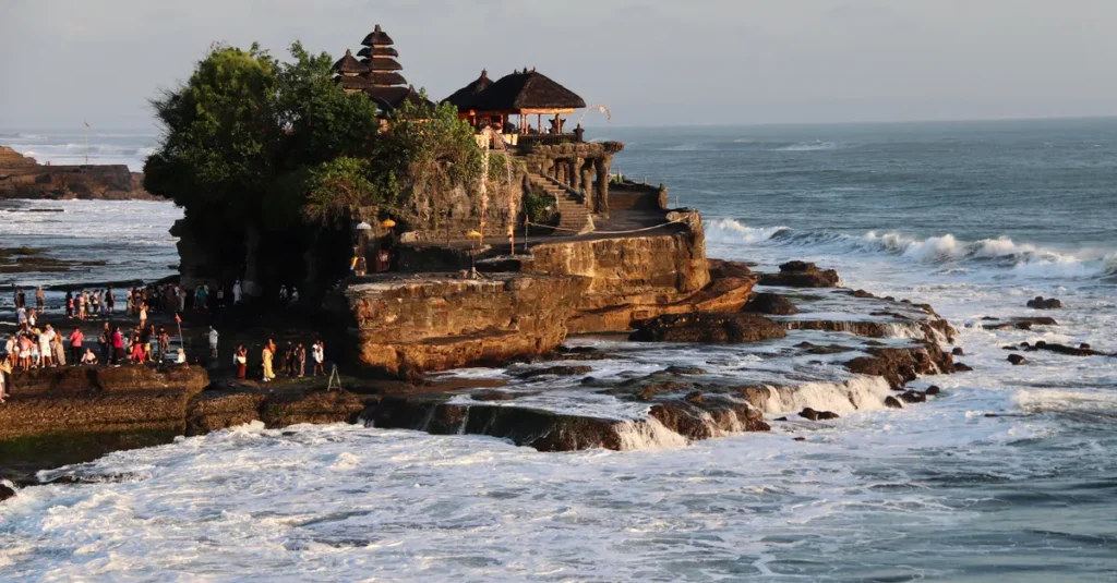 Breathtaking view of Tanah Lot Temple on the rocky coast of Bali, Indonesia, during sunset.