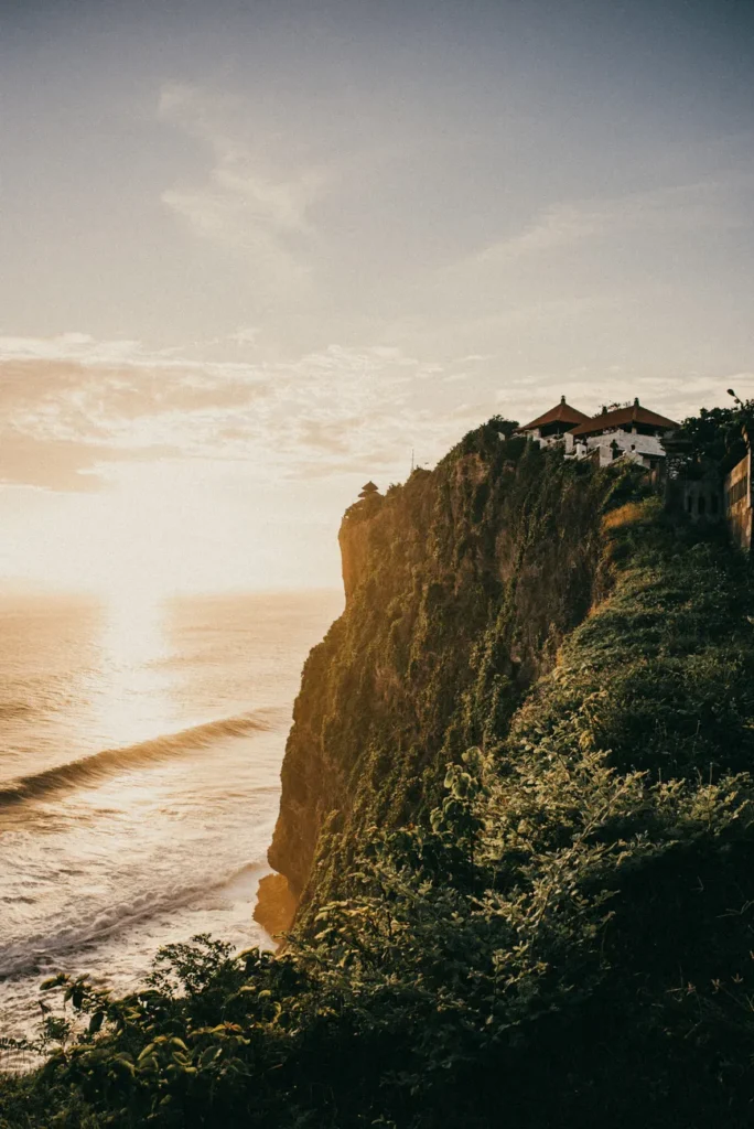 Breathtaking view of Uluwatu cliffs in Bali with ocean at sunset. Ideal for travel and nature enthusiasts.