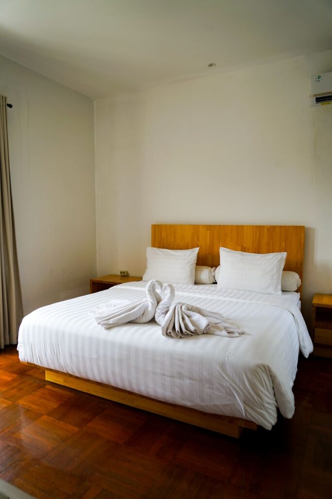 Bright and tidy hotel room featuring a double bed adorned with creative towel art.