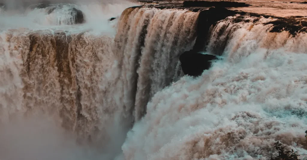 Captivating sunset view of Iguazu Falls, showcasing the powerful cascade and mist.