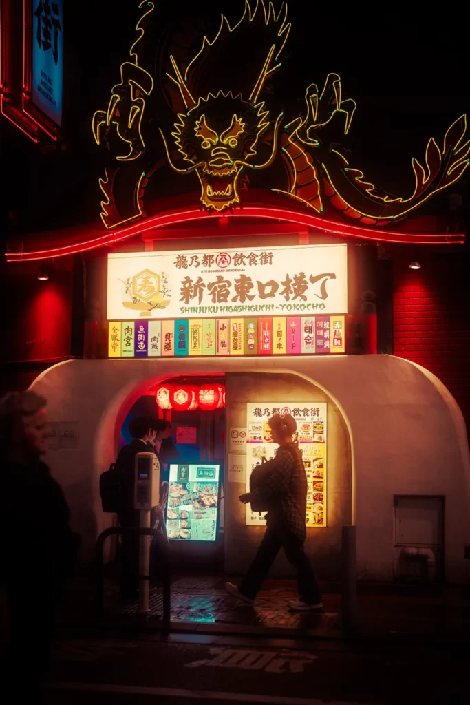 Capturing a neon-lit dragon sign in Tokyo's lively Shinjuku district at night.