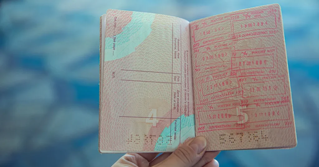 Timor-Leste à deux : le visa à l’arrivée et un mini-séjour à Dili (sans galérer) Close-up view of an open passport displaying various travel stamps in an airport setting.