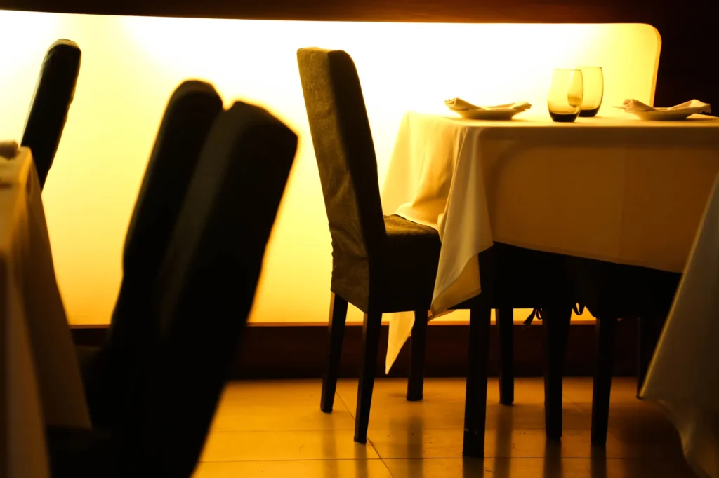 Cozy restaurant setting with elegantly set table and warm ambient lighting.