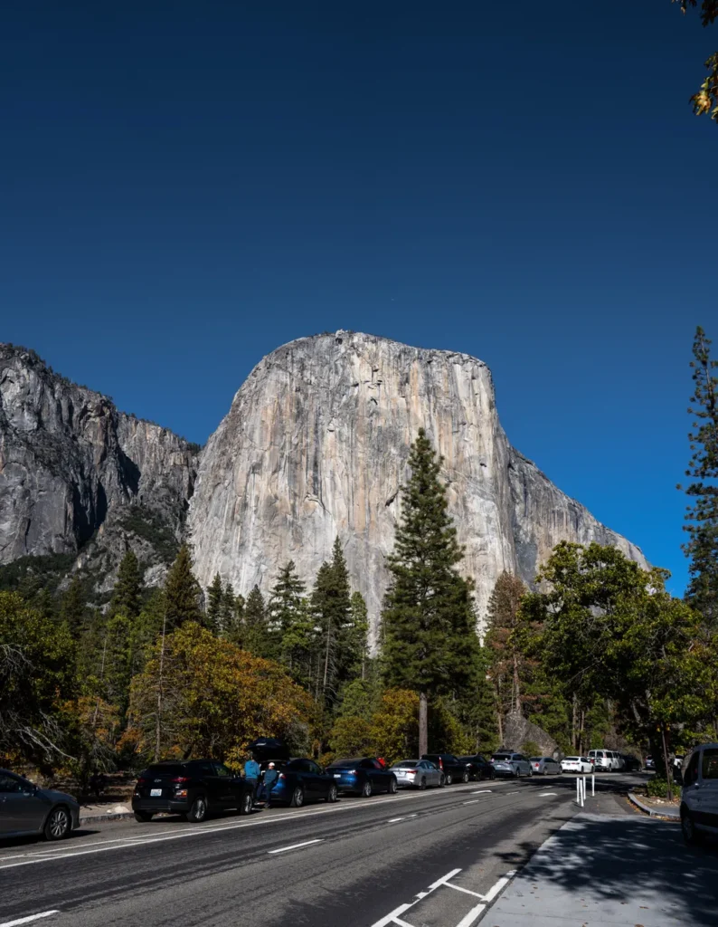 El Capitan rock formation in Yosemite Valley, showcasing the beautiful forested landscape and road.