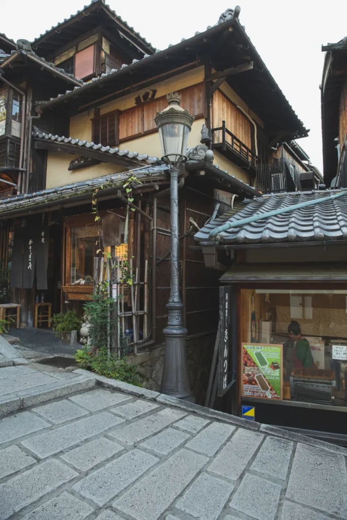 Exterior of old traditional oriental houses and authentic streetlamp located on paved pedestrian street in Higashiyama district of Kyoto