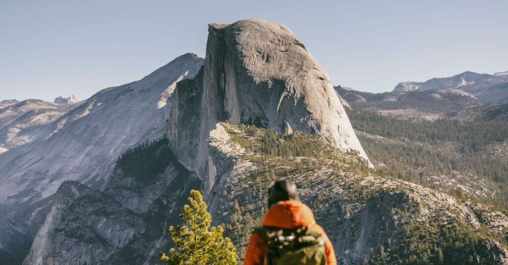 Half Dome à deux dans Yosemite : permis, timing et sécurité (sans compromis romantique) Hiker admires the majestic view of Half Dome in Yosemite National Park during fall.