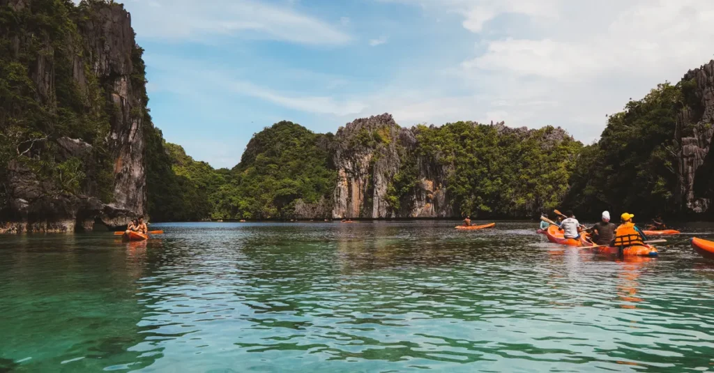 El Nido à deux (Palawan) : comment y aller, où dormir, quoi faire sans se ruiner Kayakers enjoy the stunning limestone cliffs and turquoise waters of El Nido, Palawan.
