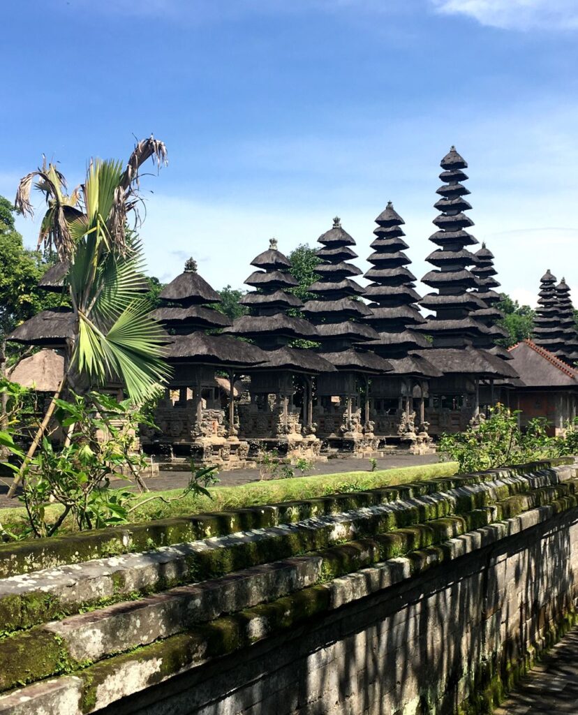 Scenic view of Taman Ayun Temple showcasing traditional Balinese architecture under clear blue skies.