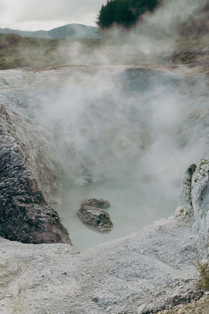 Steaming geothermal landscape showcasing a volcanic hot spring in New Zealand's natural setting.