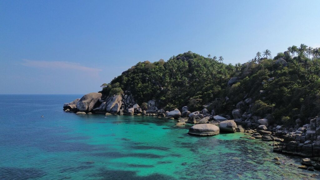 Stunning aerial view of the turquoise waters and lush landscape of Shark Bay, Ko Tao, Thailand.