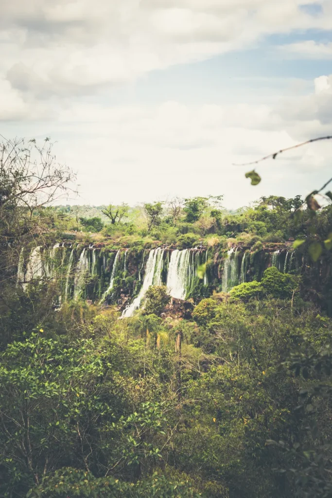 Stunning landscape of Iguazú Waterfalls with lush greenery captured on a cloudy day.