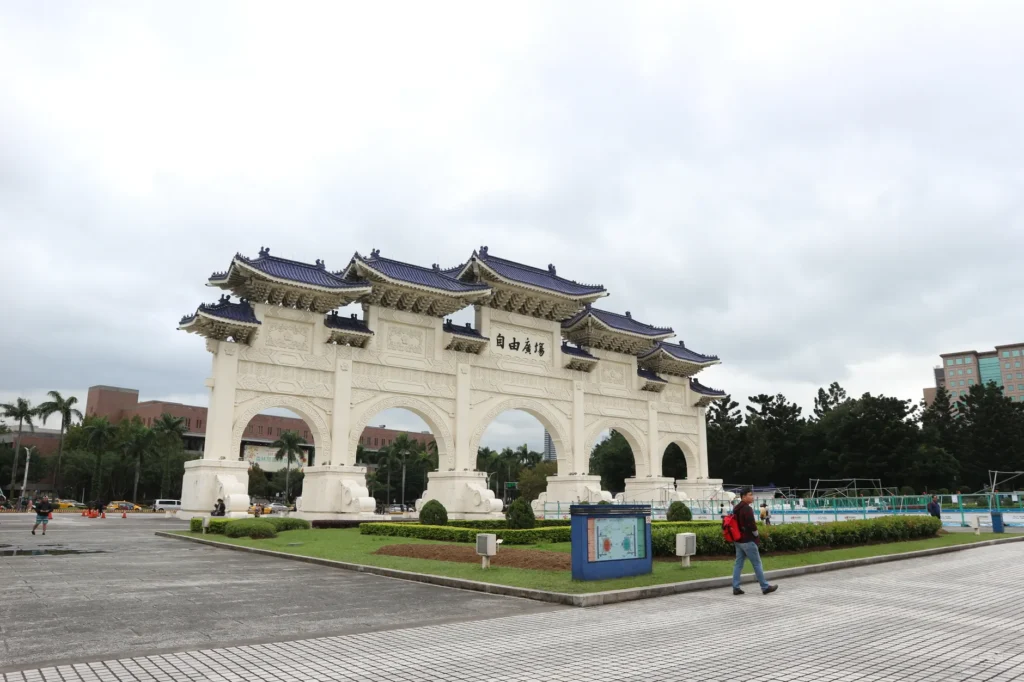 The iconic Liberty Square Arch in Taipei, Taiwan features traditional Chinese architecture with tourists nearby.