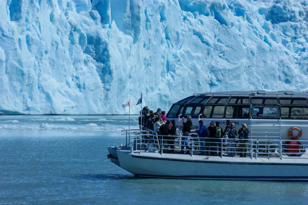 Tourists on a boat exploring icy glaciers in Patagonia's stunning landscape.