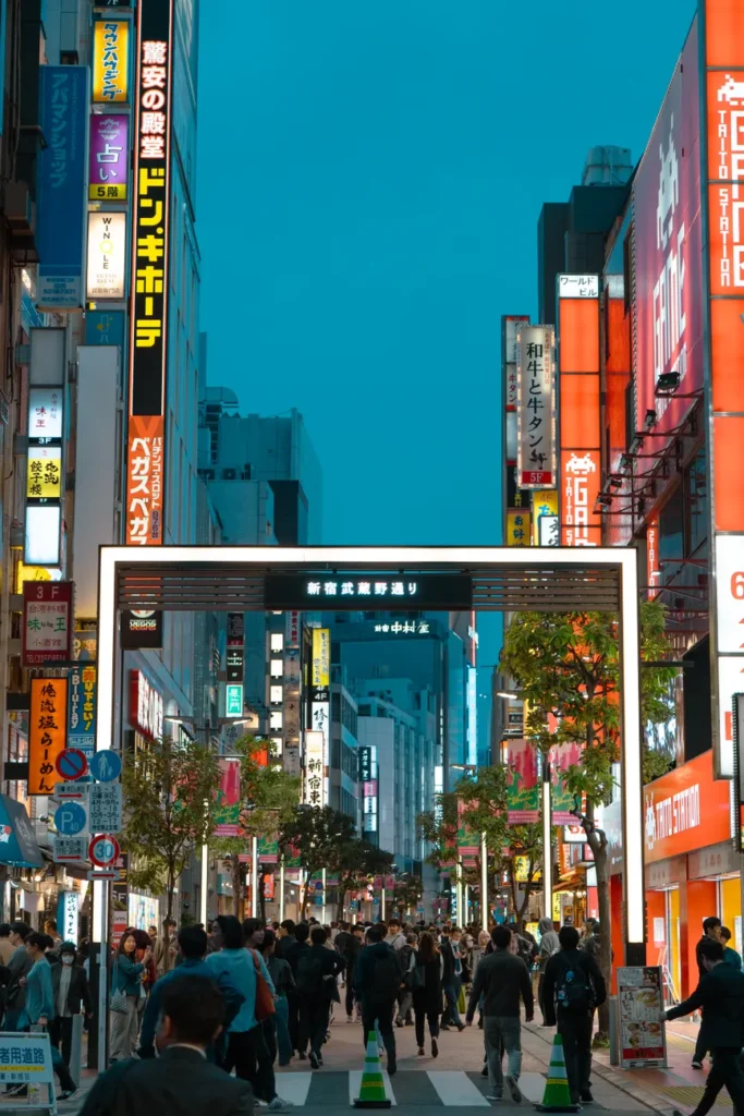 Vibrant evening scene depicting crowded Shinjuku street with bright neon signs in Tokyo, Japan.