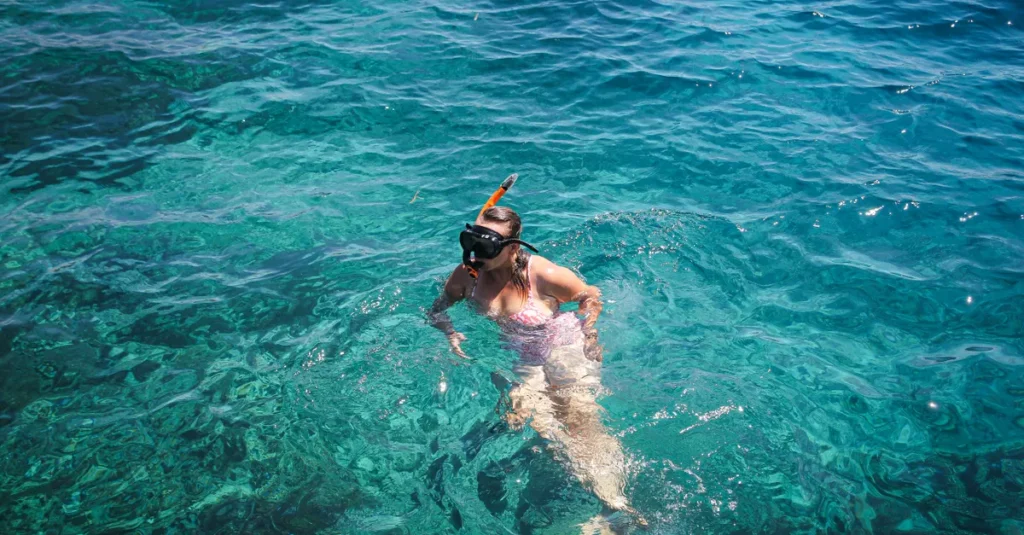 Buddha Point à Nusa Penida : voir l’incroyable… ou quoi faire à la place en couple Woman snorkeling in the clear turquoise waters of East Nusa Tenggara, Indonesia.