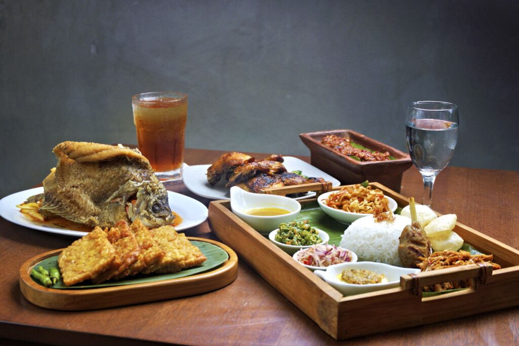 A beautifully presented diverse Indonesian meal showcasing various traditional dishes.