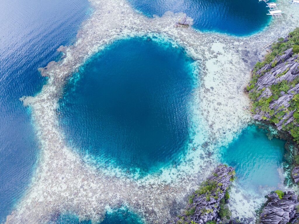 A breathtaking aerial shot of Twin Lagoons in Coron, highlighting the vibrant blue water and unique rock formations.