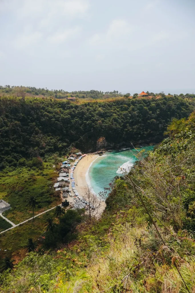 A breathtaking aerial view of a beach surrounded by lush greenery in Nusa Penida, Bali, Indonesia.