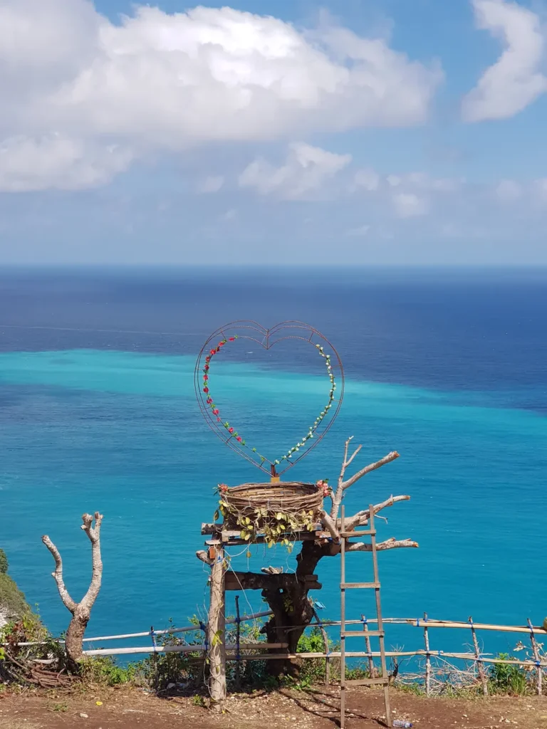 A heart frame decorates a beautiful ocean cliff in Nusa Penida, Bali.