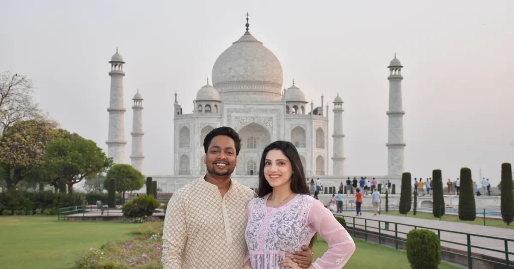 Visiter le Taj Mahal en couple : le guide concret pour y aller sans stress (Agra, rythme & pièges) A joyful couple stands in front of the stunning Taj Mahal, capturing a moment of love and heritage.