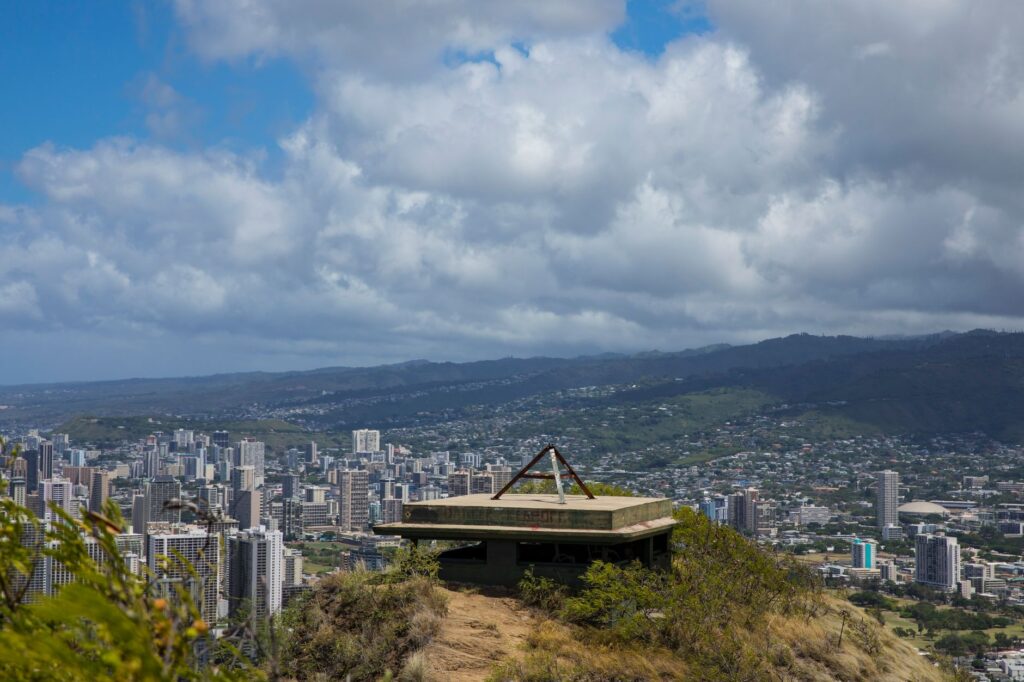A scenic overlook provides a panoramic view of Honolulu, Hawaii under a cloudy sky.