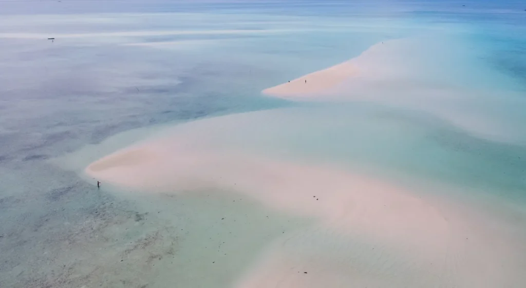 A serene aerial view showcasing sandy beaches merging with clear, turquoise waters, embodying a perfect summer escape.