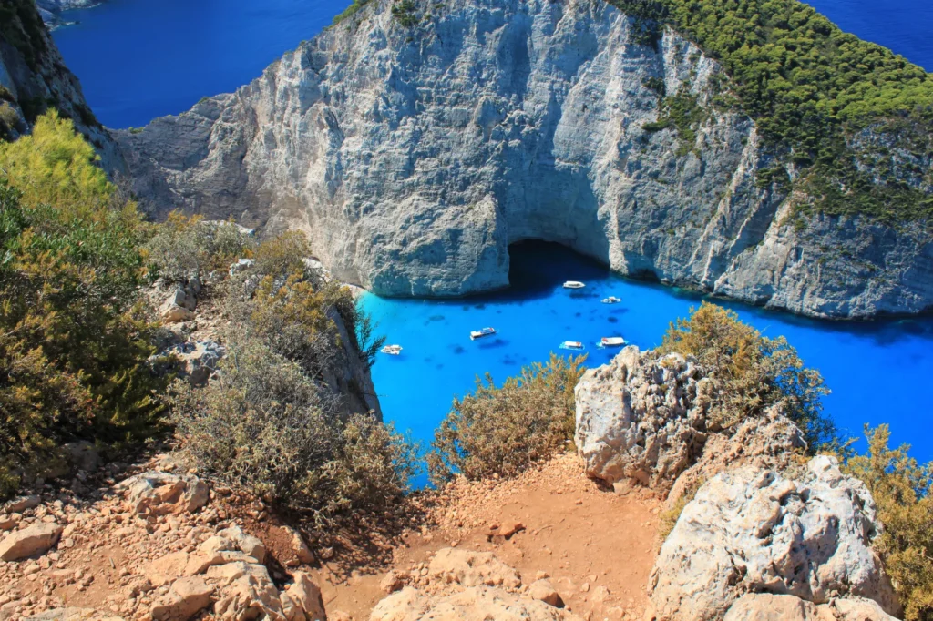 A stunning aerial view of Navagio Beach with turquoise waters, cliffs, and boats in Zakynthos, Greece.
