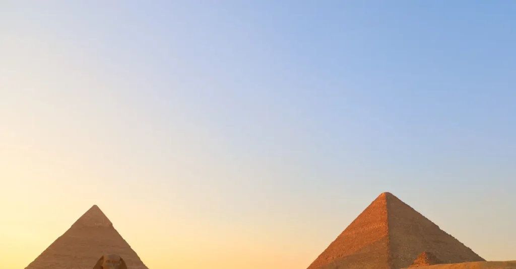 Visiter les pyramides de Gizeh à deux : le guide concret (sans se cramer, ni se faire embarquer) A stunning view of the Giza pyramids and Sphinx during sunset in Cairo, Egypt.
