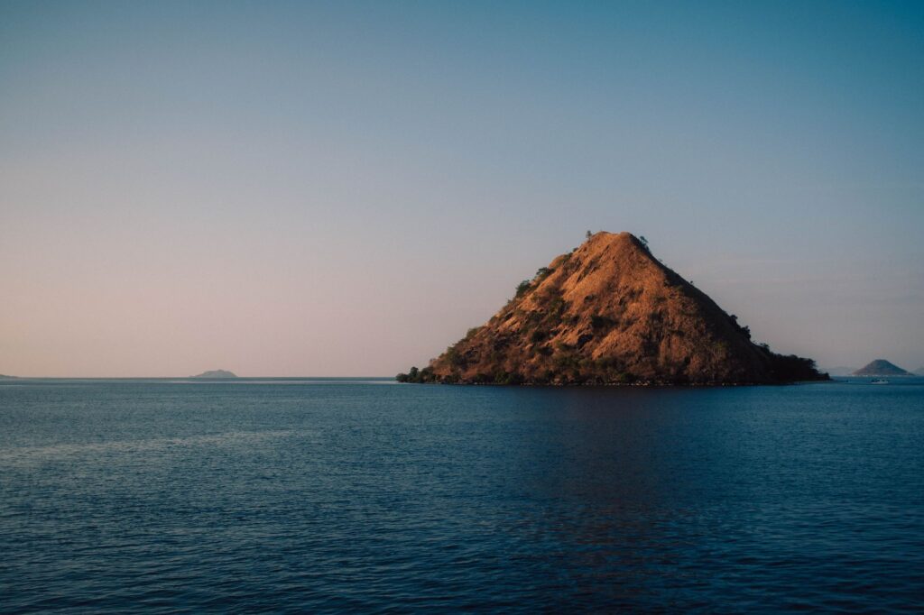 A tranquil view of Kukusan Island in Komodo National Park during sunset.