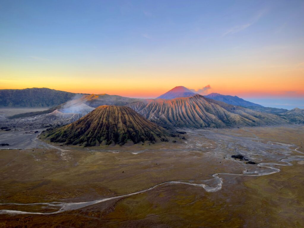 Aerial view of Mount Bromo in East Java, Indonesia, showcasing vibrant colors at sunrise.