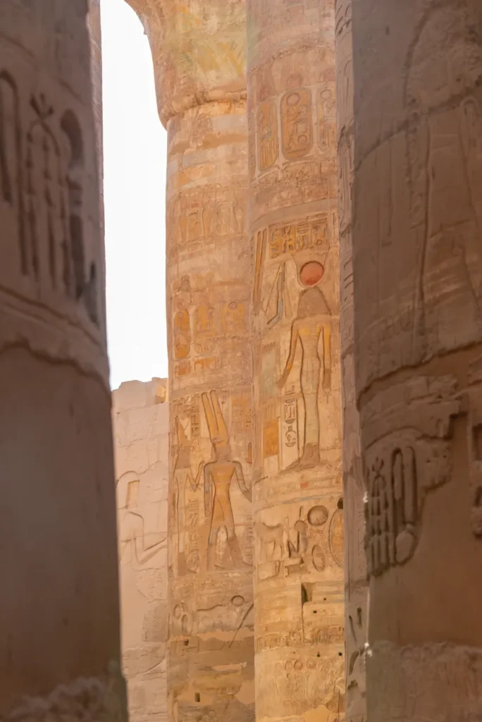 Ancient carved columns in Karnak Temple, Luxor, Egypt, showcasing exquisite hieroglyphics.