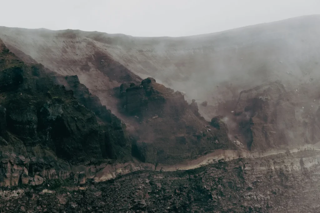 Atmospheric view of Mount Vesuvius crater engulfed in mist, capturing the rugged volcanic landscape.