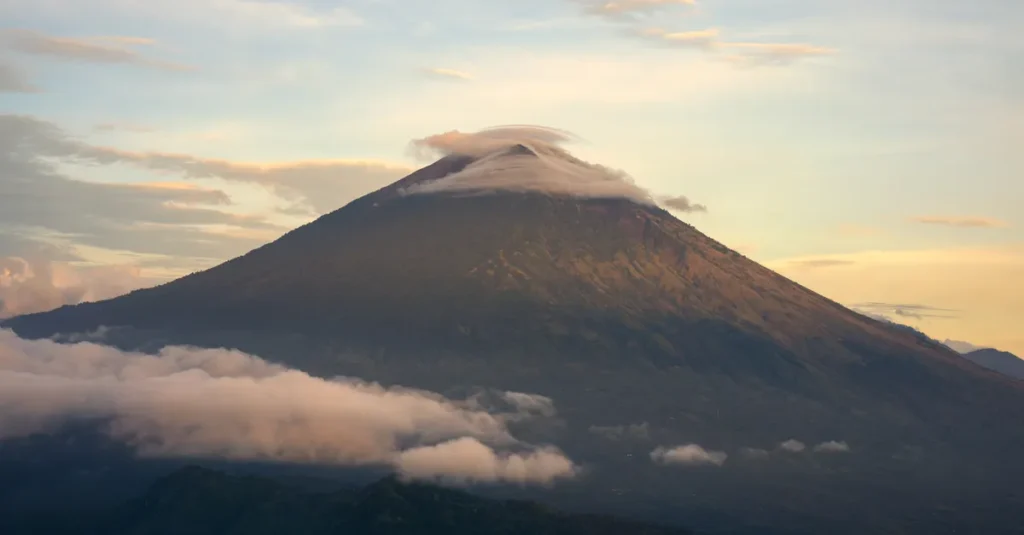 Mont Agung en couple : le guide concret du sunrise trek (sans jouer les héros) Beautiful view of Mount Agung surrounded by clouds at sunrise in Bali, Indonesia.