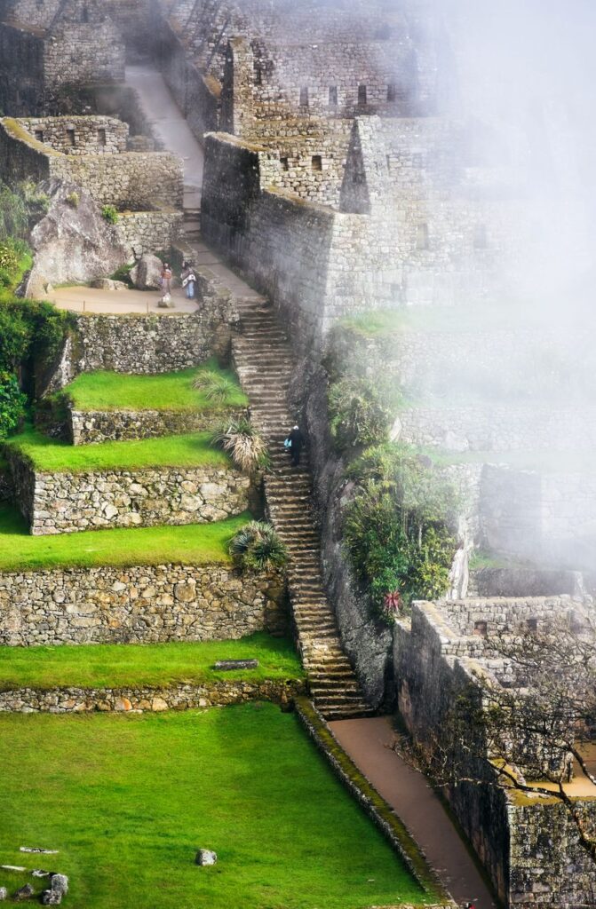 Breathtaking view of Machu Picchu's ancient stone structures enveloped in mist, highlighting Incan architecture.