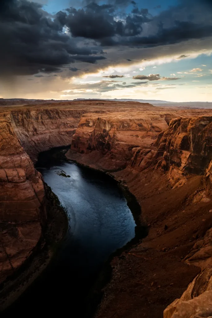 Breathtaking view of the Horseshoe Bend in Arizona during a dramatic sunset with storm clouds.
