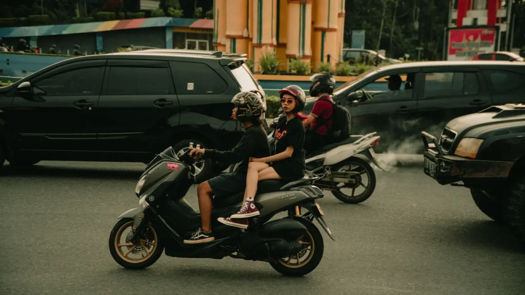 Busy city intersection with scooters and cars amidst traffic.