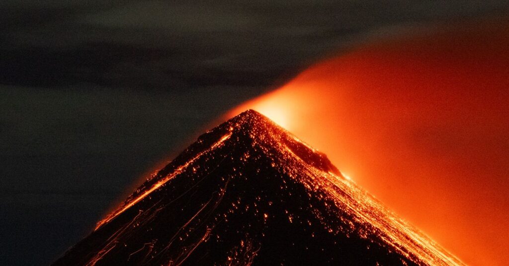 Acatenango à deux : dormir au-dessus des nuages et regarder le Volcán de Fuego cracher la nuit Captivating nighttime eruption of Acatenango volcano in Guatemala, showcasing flowing lava and ash.