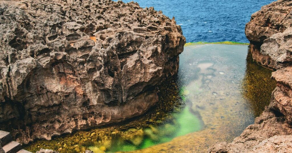 Tembeling Beach à Nusa Penida : la baignade naturelle “hidden spot” à faire en couple (avec le bon timing) Captivating view of Angel's Billabong showcasing rugged cliffs and clear sea in Bali, Indonesia.