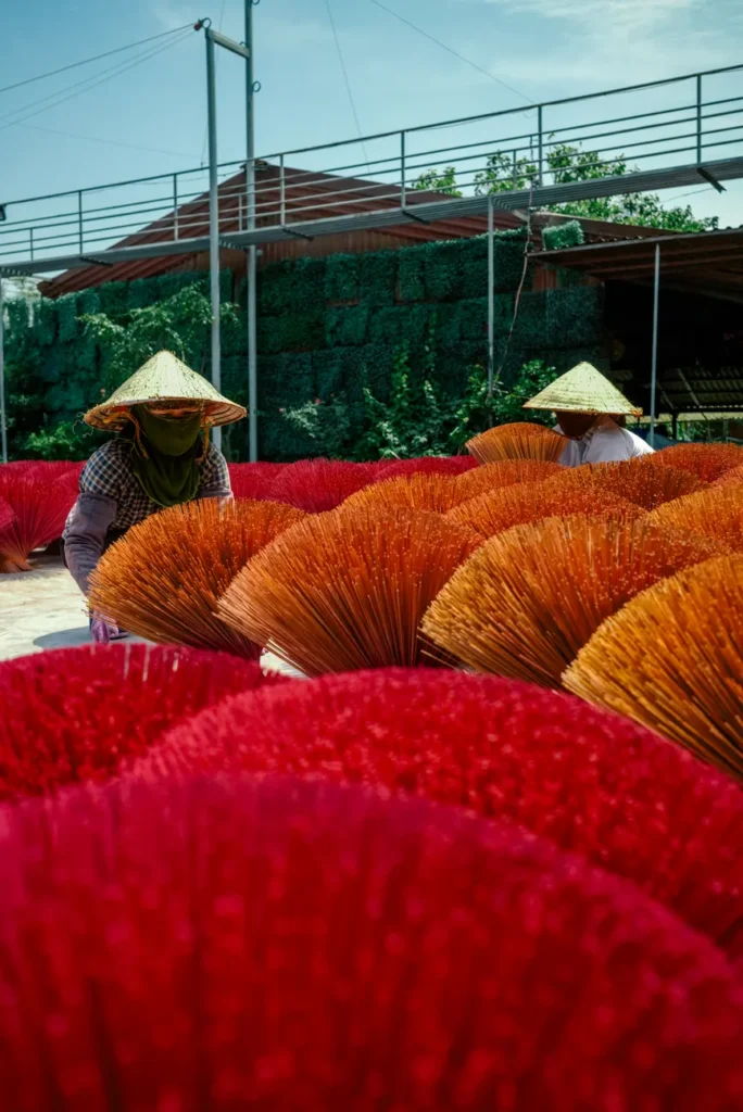 Colorful incense sticks drying under the sun in Hanoi. Traditional Vietnamese craft captured in vibrant detail.