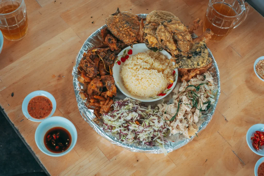 Delicious Nasi Uduk platter with fried fish and chicken, a perfect Indonesian meal.
