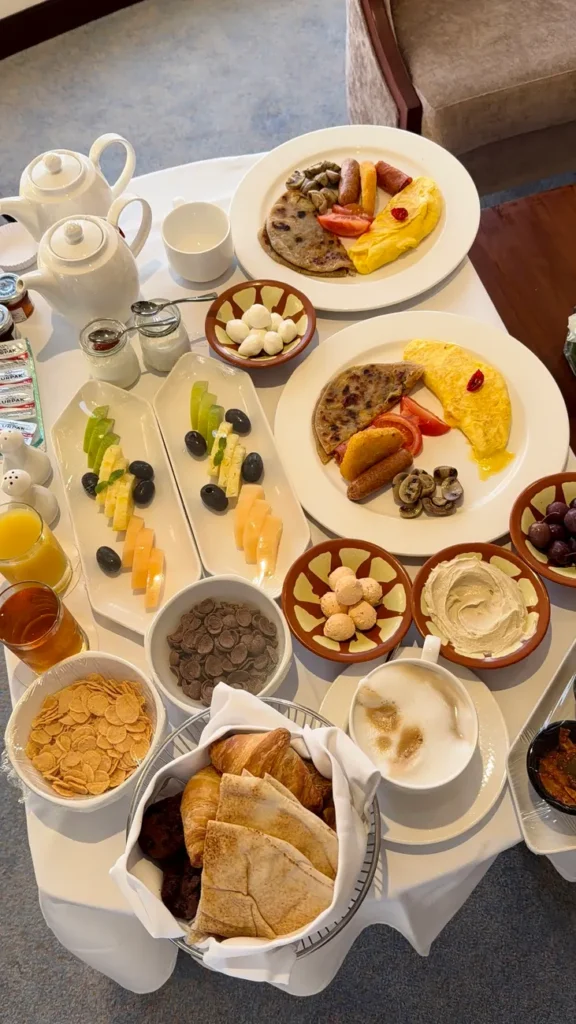 Deluxe breakfast spread featuring omelettes, pancakes, fruits, and pastries.