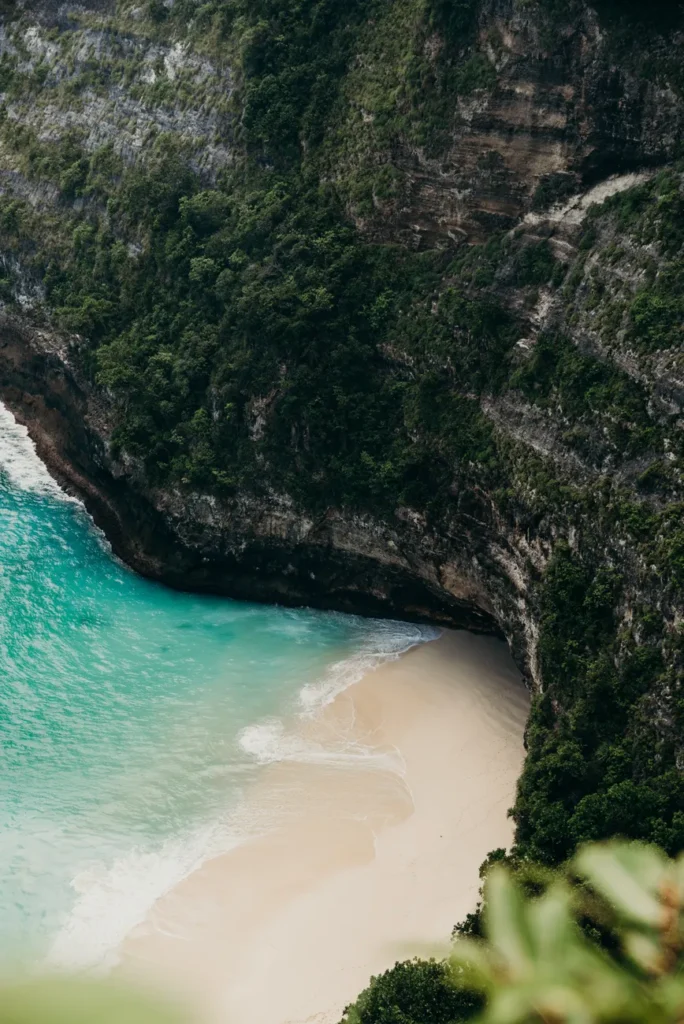 Discover Bali's breathtaking cliffside beach with turquoise waters and lush greenery, perfect for tropical travel inspiration.